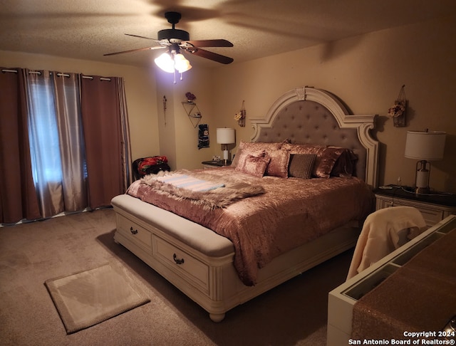 carpeted bedroom with ceiling fan and a textured ceiling