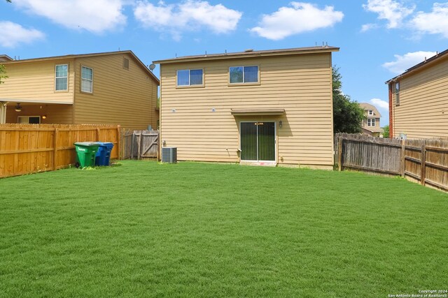 back of property featuring a yard and central AC