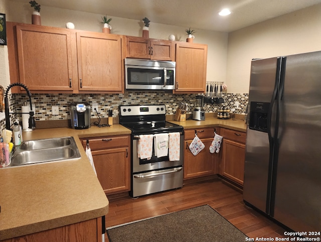 kitchen with backsplash, sink, dark hardwood / wood-style floors, and appliances with stainless steel finishes