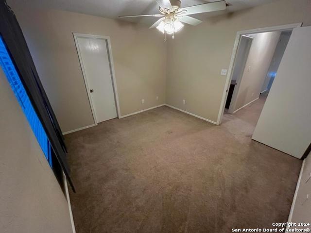 carpeted empty room featuring ceiling fan