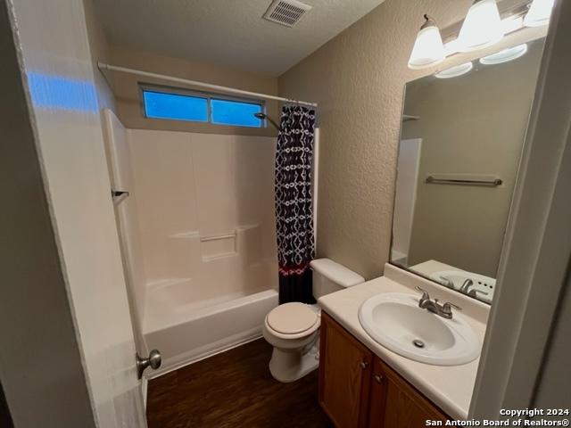 full bathroom featuring toilet, shower / bath combo with shower curtain, vanity, and hardwood / wood-style flooring