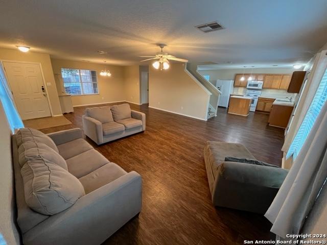 living room featuring ceiling fan and dark hardwood / wood-style floors