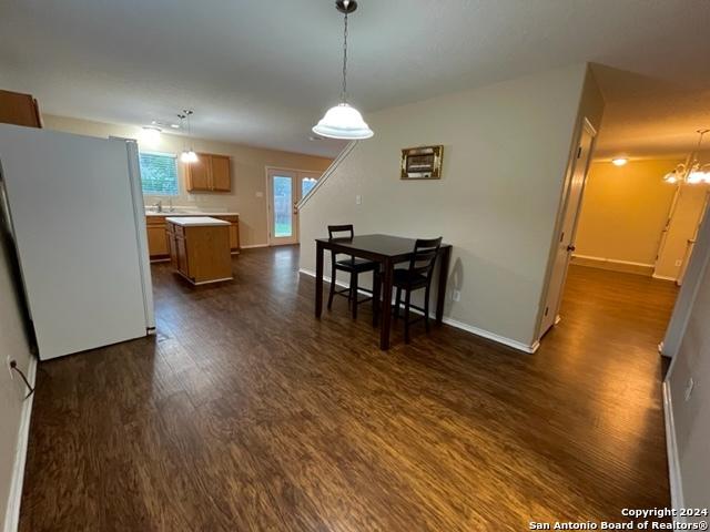 dining room with dark wood-type flooring and a chandelier