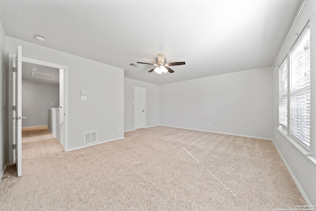 spare room with ceiling fan and light colored carpet