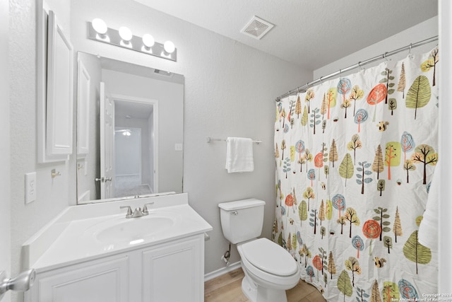 bathroom featuring hardwood / wood-style floors, a textured ceiling, toilet, vanity, and a shower with shower curtain