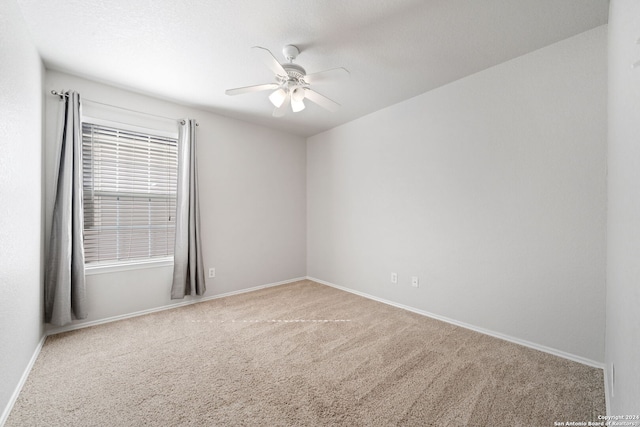 carpeted spare room with ceiling fan