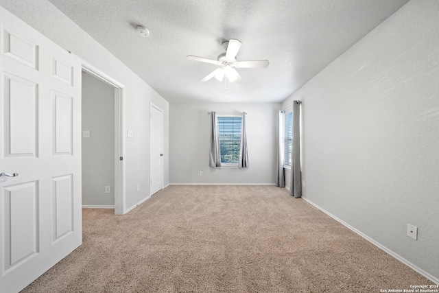 carpeted empty room featuring a textured ceiling and ceiling fan