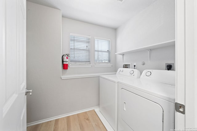 laundry area featuring washer and clothes dryer and light wood-type flooring