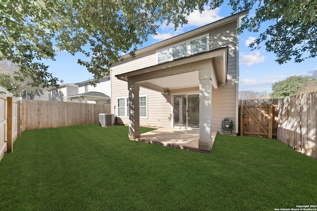 rear view of house with a patio area, a yard, and cooling unit