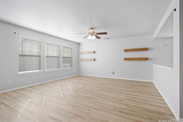 empty room with ceiling fan, a textured ceiling, and light hardwood / wood-style flooring