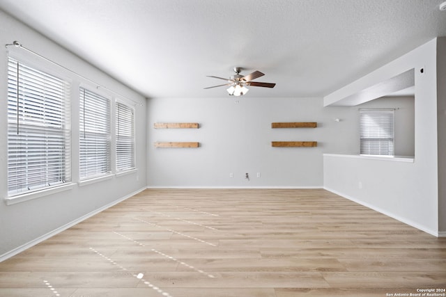 unfurnished room featuring a textured ceiling, light hardwood / wood-style flooring, and ceiling fan