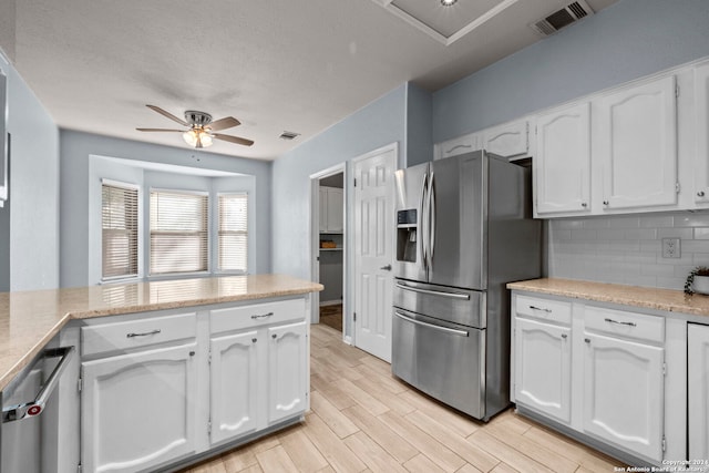 kitchen with white cabinets, light wood-type flooring, stainless steel appliances, and ceiling fan