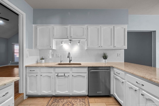 kitchen with white cabinetry, sink, stainless steel dishwasher, and lofted ceiling