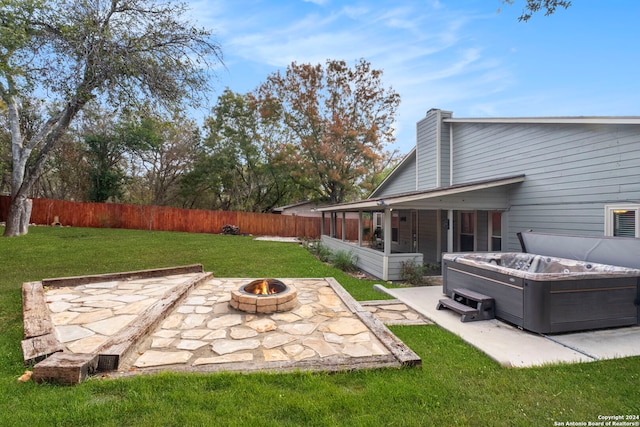 view of yard with a fire pit, a sunroom, central AC, a patio area, and a hot tub