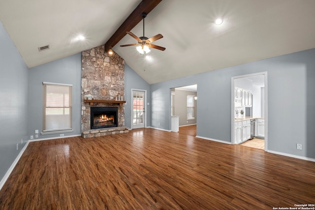 unfurnished living room with light wood-type flooring, a stone fireplace, and a wealth of natural light