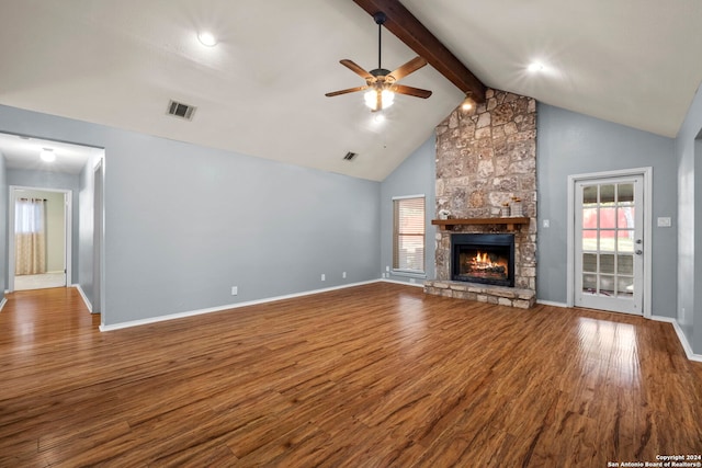 unfurnished living room featuring high vaulted ceiling, a stone fireplace, hardwood / wood-style flooring, ceiling fan, and beam ceiling