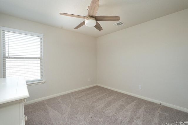 spare room with ceiling fan and light colored carpet