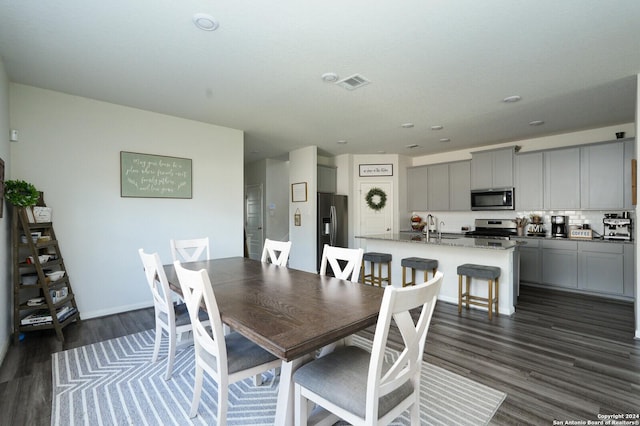 dining space with dark hardwood / wood-style flooring and sink