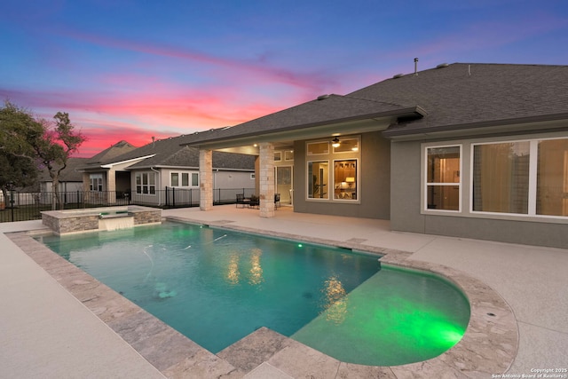 pool at dusk with an in ground hot tub, ceiling fan, and a patio