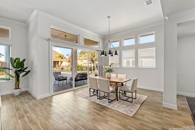 dining space with ornamental molding and a chandelier