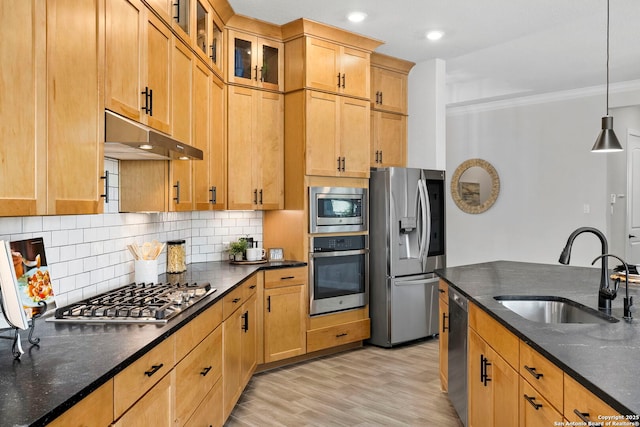 kitchen with sink, hanging light fixtures, decorative backsplash, appliances with stainless steel finishes, and light wood-type flooring