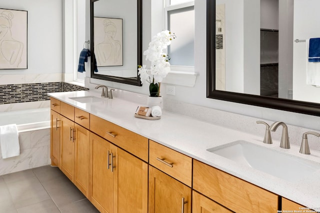 bathroom featuring tile patterned floors, tiled tub, plenty of natural light, and vanity