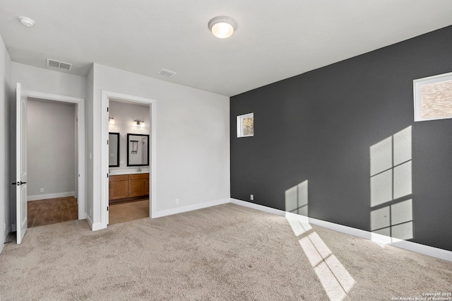 interior space with light carpet and connected bathroom