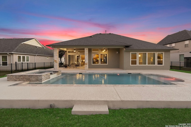 pool at dusk with an in ground hot tub, ceiling fan, and a patio