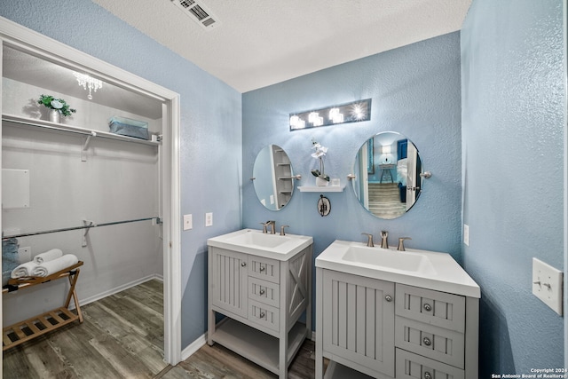 bathroom featuring vanity, wood-type flooring, and a textured ceiling