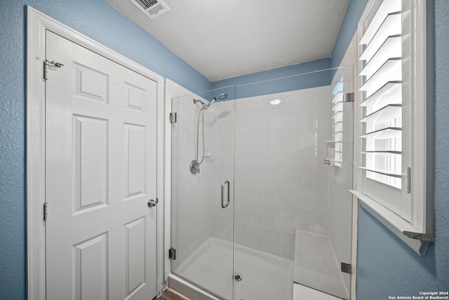 bathroom featuring a shower with door