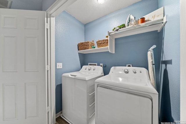 washroom featuring washing machine and dryer and a textured ceiling