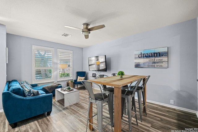 dining room featuring ceiling fan, a textured ceiling, and hardwood / wood-style flooring