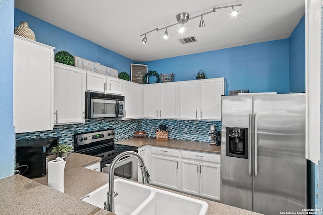 kitchen with white cabinets, stainless steel appliances, tasteful backsplash, and sink