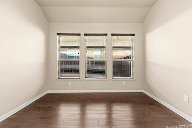 unfurnished room with dark hardwood / wood-style flooring, lofted ceiling, and a wealth of natural light