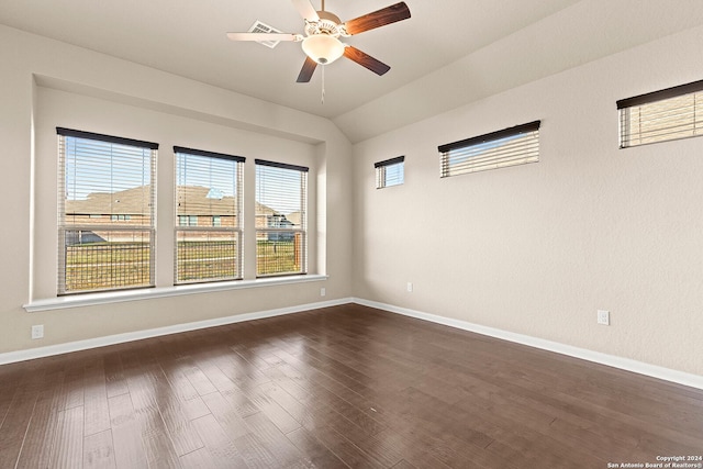 spare room with ceiling fan, dark wood-type flooring, and vaulted ceiling