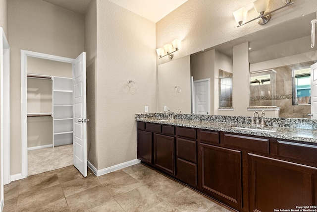 bathroom featuring tile patterned floors, vanity, a textured ceiling, and tiled shower