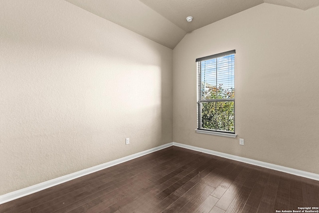 unfurnished room featuring dark wood-type flooring and vaulted ceiling