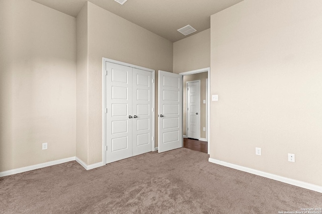 unfurnished bedroom featuring carpet and a closet