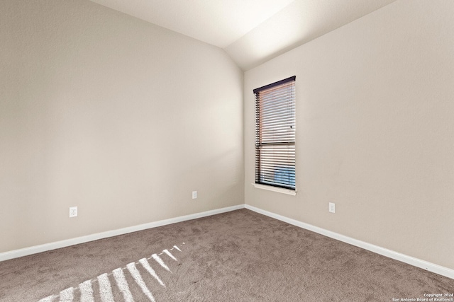 empty room featuring carpet floors and lofted ceiling