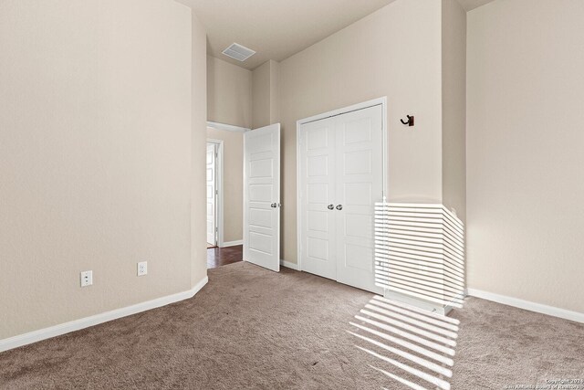 unfurnished bedroom with light carpet and a closet