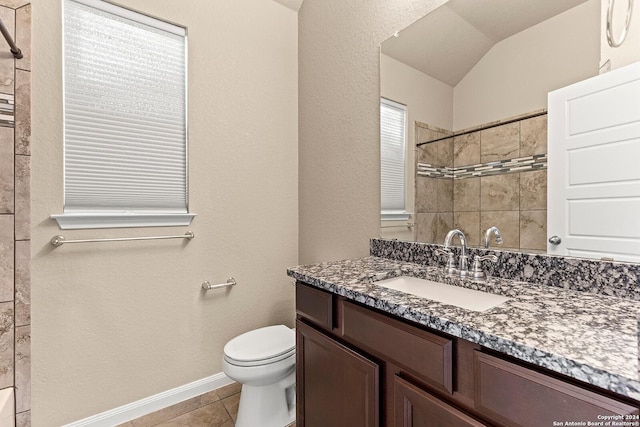 bathroom featuring tile patterned floors, vanity, toilet, and vaulted ceiling