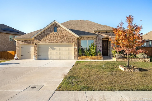 view of front of property featuring a front yard and a garage