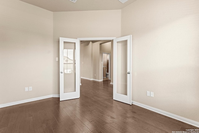 unfurnished room with french doors, high vaulted ceiling, and dark wood-type flooring