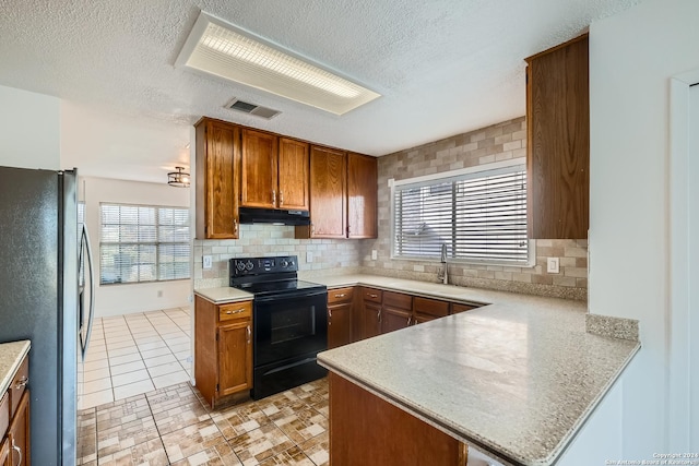 kitchen with sink, black electric range oven, kitchen peninsula, fridge, and decorative backsplash