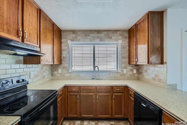 kitchen featuring black appliances, decorative backsplash, sink, and extractor fan