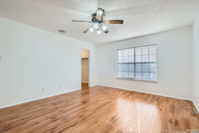 spare room featuring ceiling fan, a textured ceiling, and light hardwood / wood-style flooring