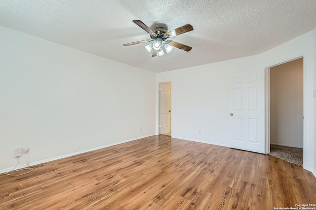 spare room with ceiling fan, a textured ceiling, and light hardwood / wood-style flooring