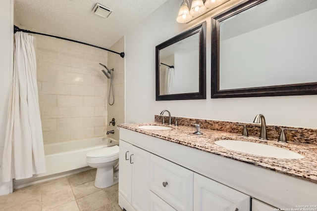 full bathroom with vanity, tile patterned floors, toilet, a textured ceiling, and shower / tub combo