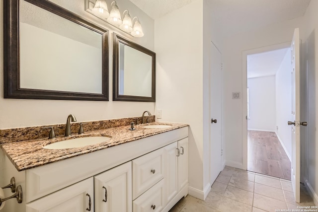 bathroom with tile patterned floors, vanity, and a textured ceiling