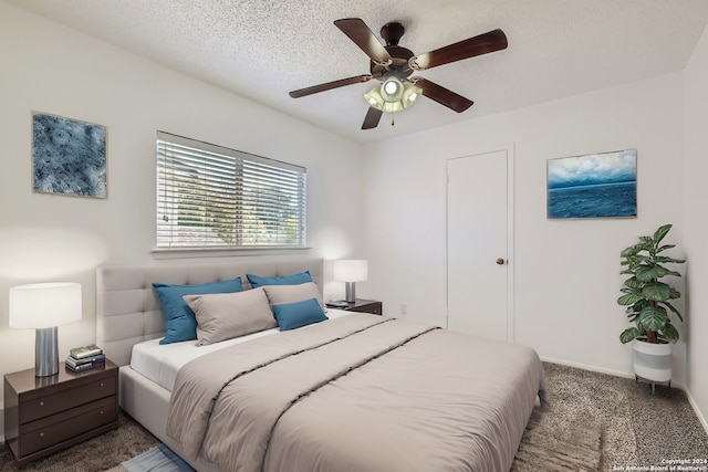 carpeted bedroom featuring a textured ceiling and ceiling fan